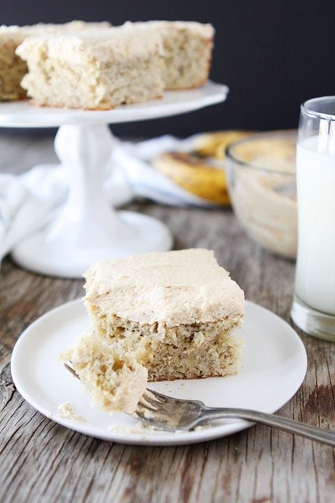 Easy Banana Cake Recipe with Peanut Butter Frosting on twopeasandtheirpod.com LOVE this cake recipe! And the frosting is dreamy! Peanut butter banana cake served with milk