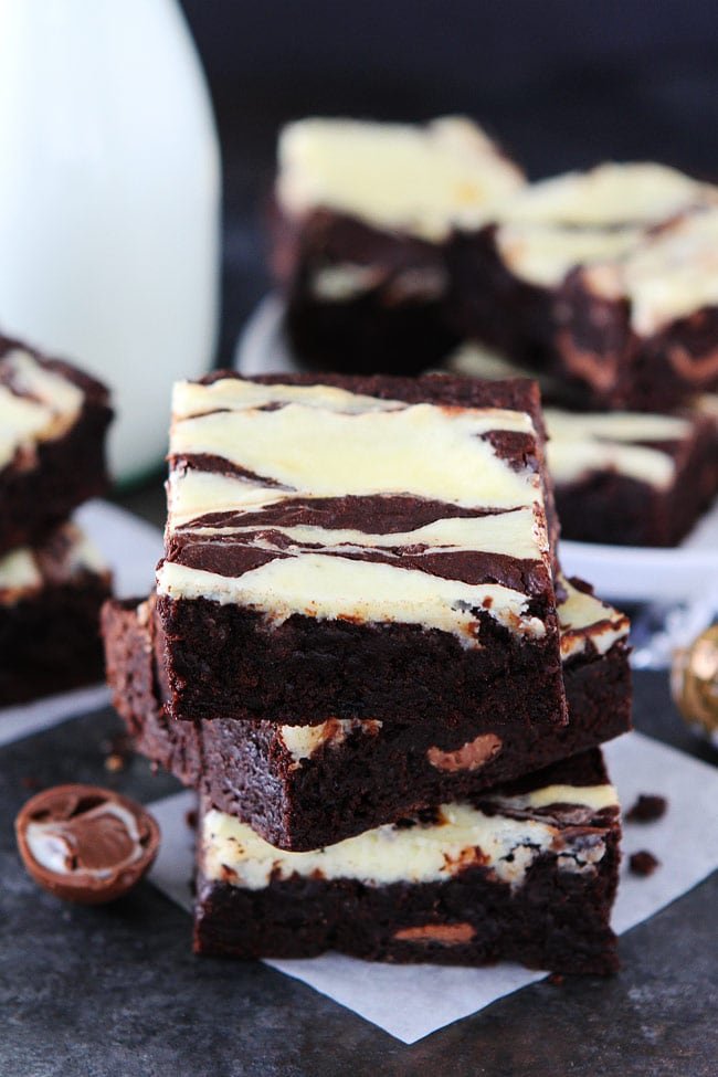 These fudgy Cheesecake Truffle Brownies have a layer of chocolate truffles and a smooth cheesecake swirl. They are the BEST brownies! Cheesecake Truffle Brownies stack