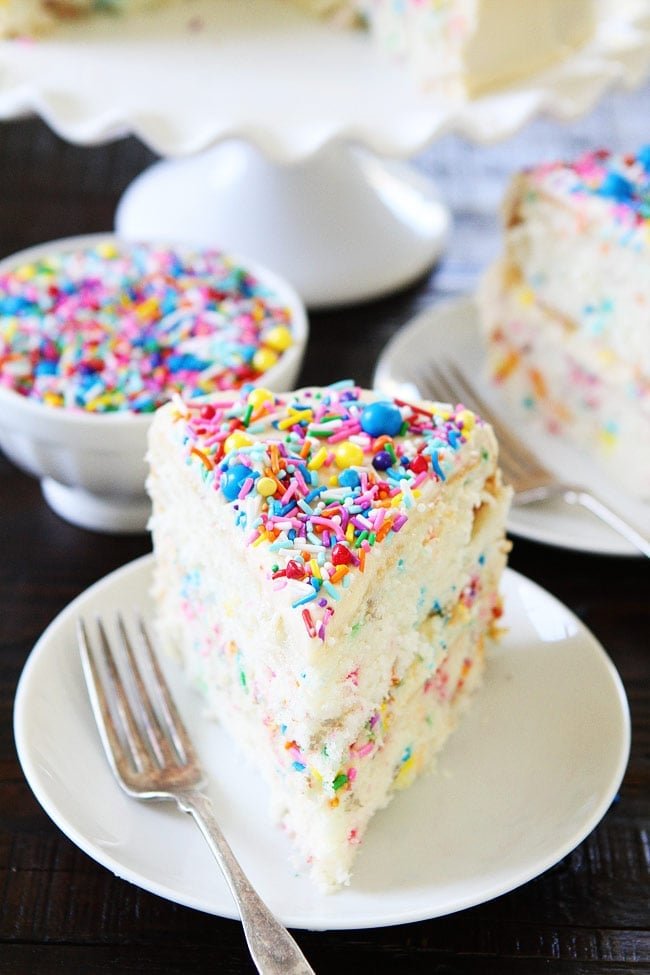 Funfetti Cake Recipe on twopeasandtheirpod.com White layer cake with sprinkles and a sweet vanilla buttercream frosting. This is the perfect cake for birthday parties or any celebration. Serving Homemade Funfetti Cake