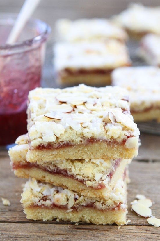Raspberry Almond Shortbread Bars Recipe on twopeasandtheirpod.com Buttery shortbread bars with raspberry jam, almond streusel, and a sweet almond glaze! A great holiday treat! Raspberry Almond Shortbread Bars