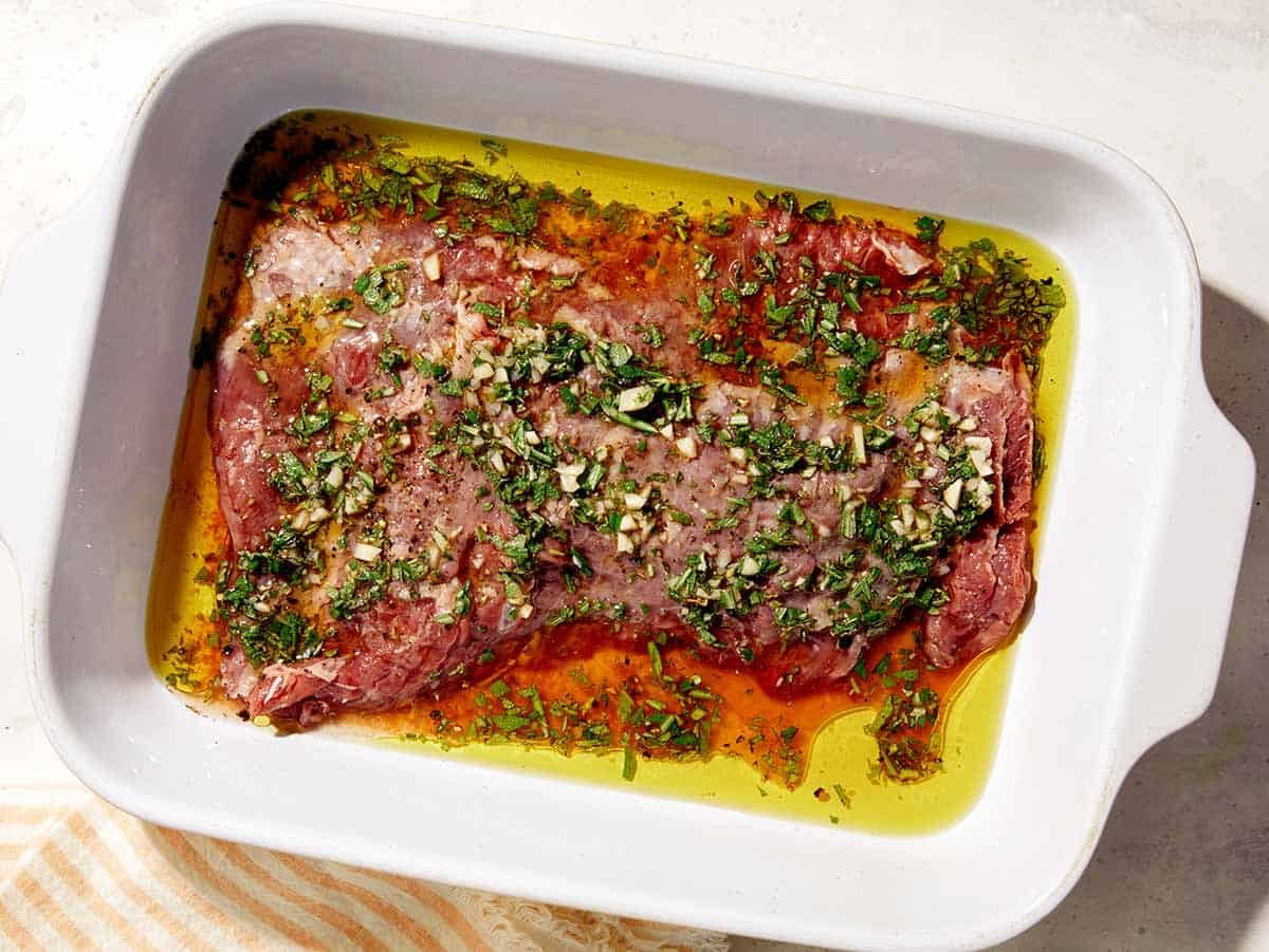 Marinated skirt steak in a baking dish.