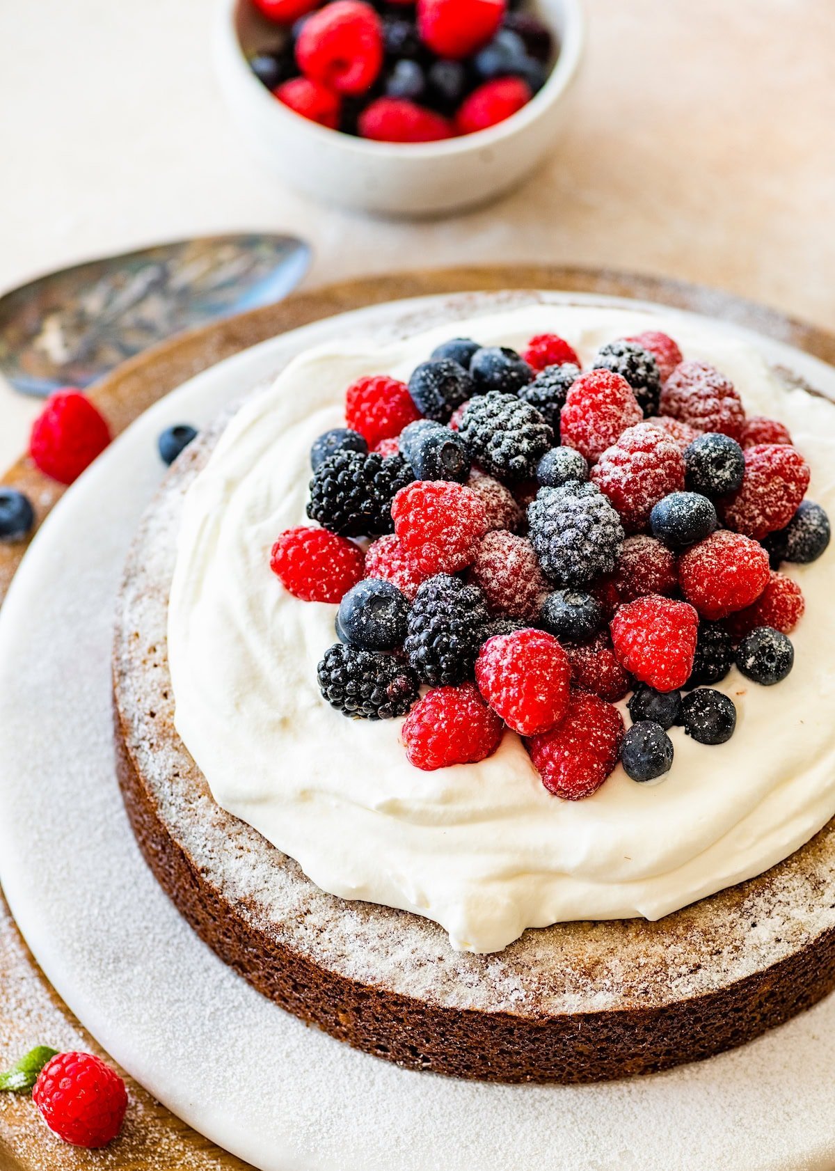 yogurt cake topped with whipped cream and fresh berries.