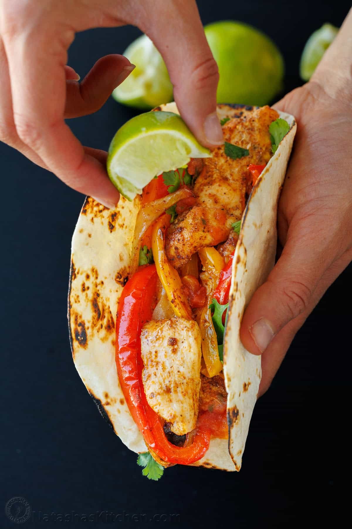 Sheet Pan Chicken Fajitas recipe packed with flavor. It's a crowd-pleasing, 30-minute, one pan meal that makes any weeknight meal a fiesta! Drizzling lime on a fajita in a tortilla