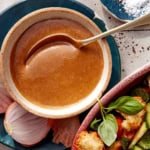 Close up on a bowl filled with balsamic vinaigrette with a spoon in it.