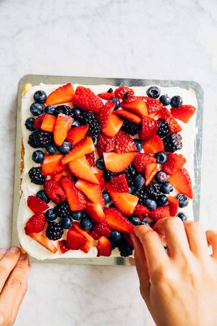 photo of Michelle from Hummingbird High covering the chantilly cream cheese frosting with the prepared berries