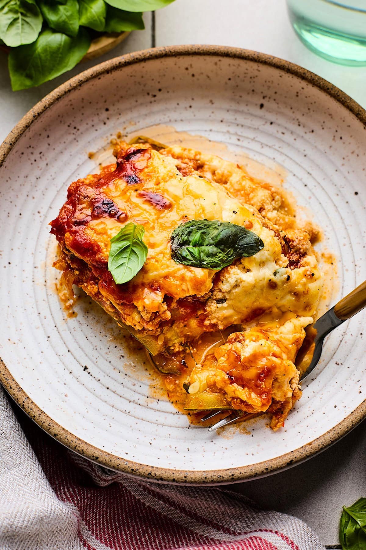 piece of zucchini lasagna on plate with fork. 