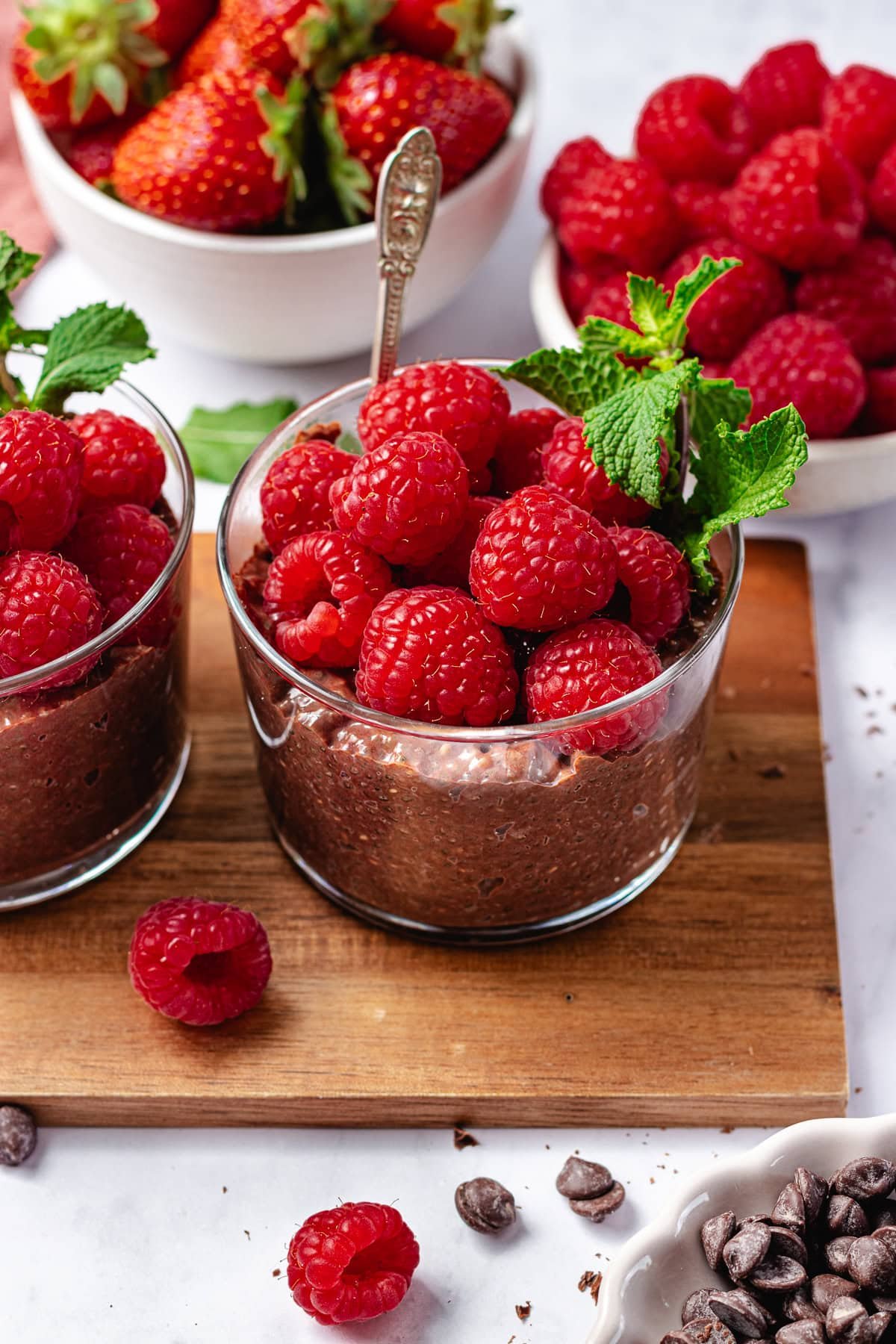 chocolate chia pudding in jars with fresh raspberries and mint.