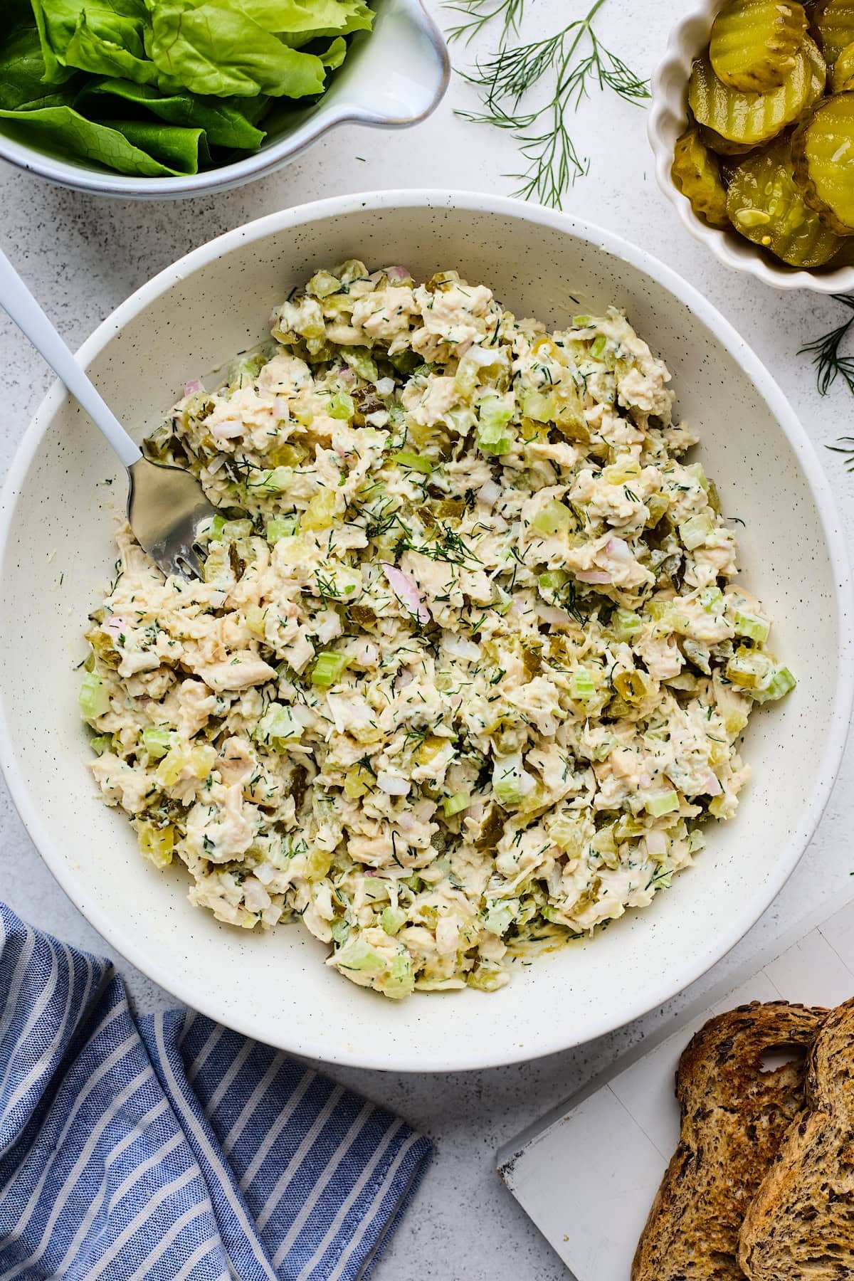 dill pickle chicken salad in bowl with fork.