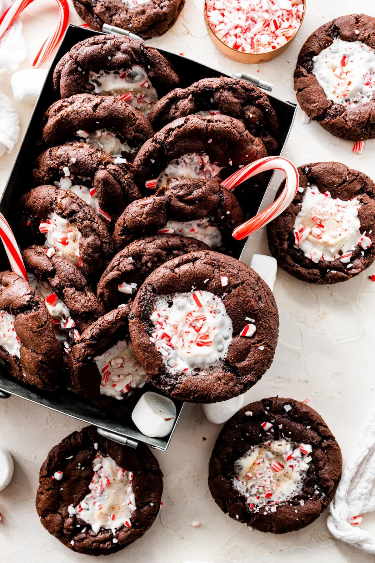 peppermint mocha marshmallow cookies in box with candy canes and marshmallows.