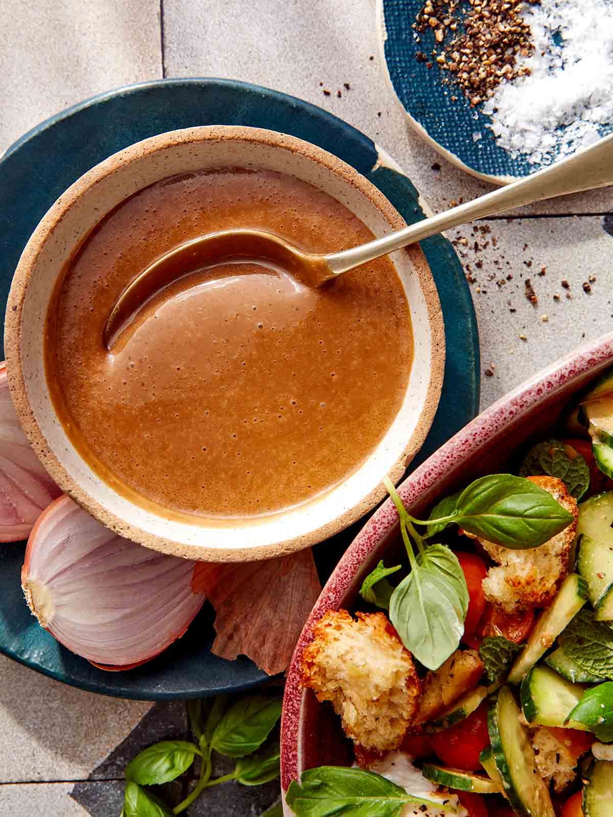 Balsamic Vinaigrette recipe in a bowl with a spoon with ingredients around it.
