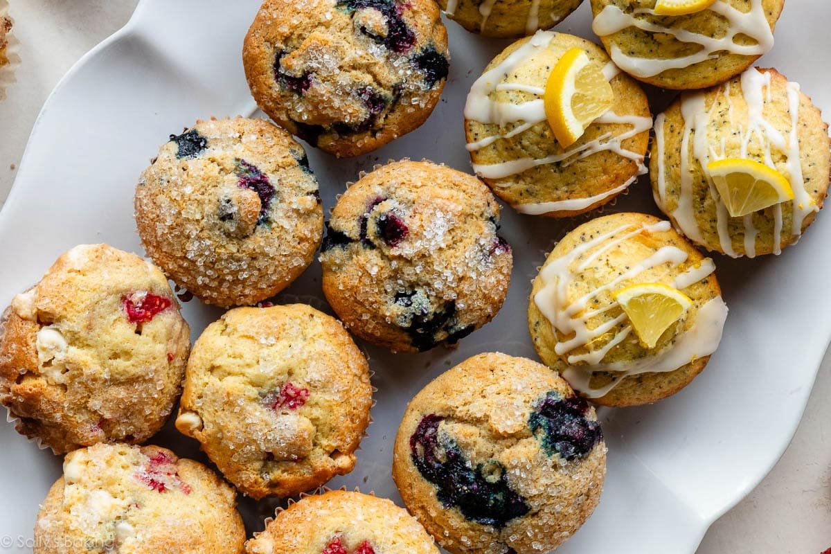 strawberry muffins, blueberry muffins, and lemon poppy seed muffins on a white platter.