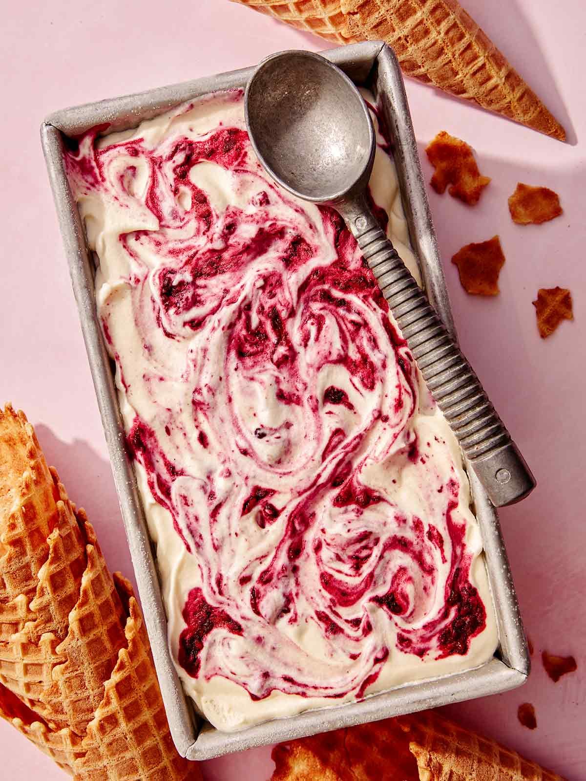 No churn ice cream in a loaf pan with a scoop on top.