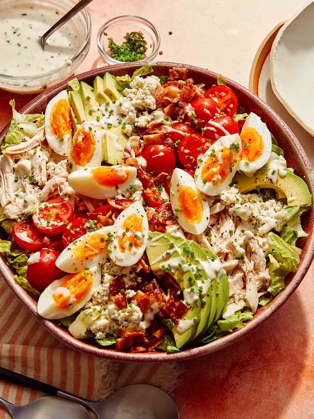 Cobb salad in a bowl ready to be tossed.