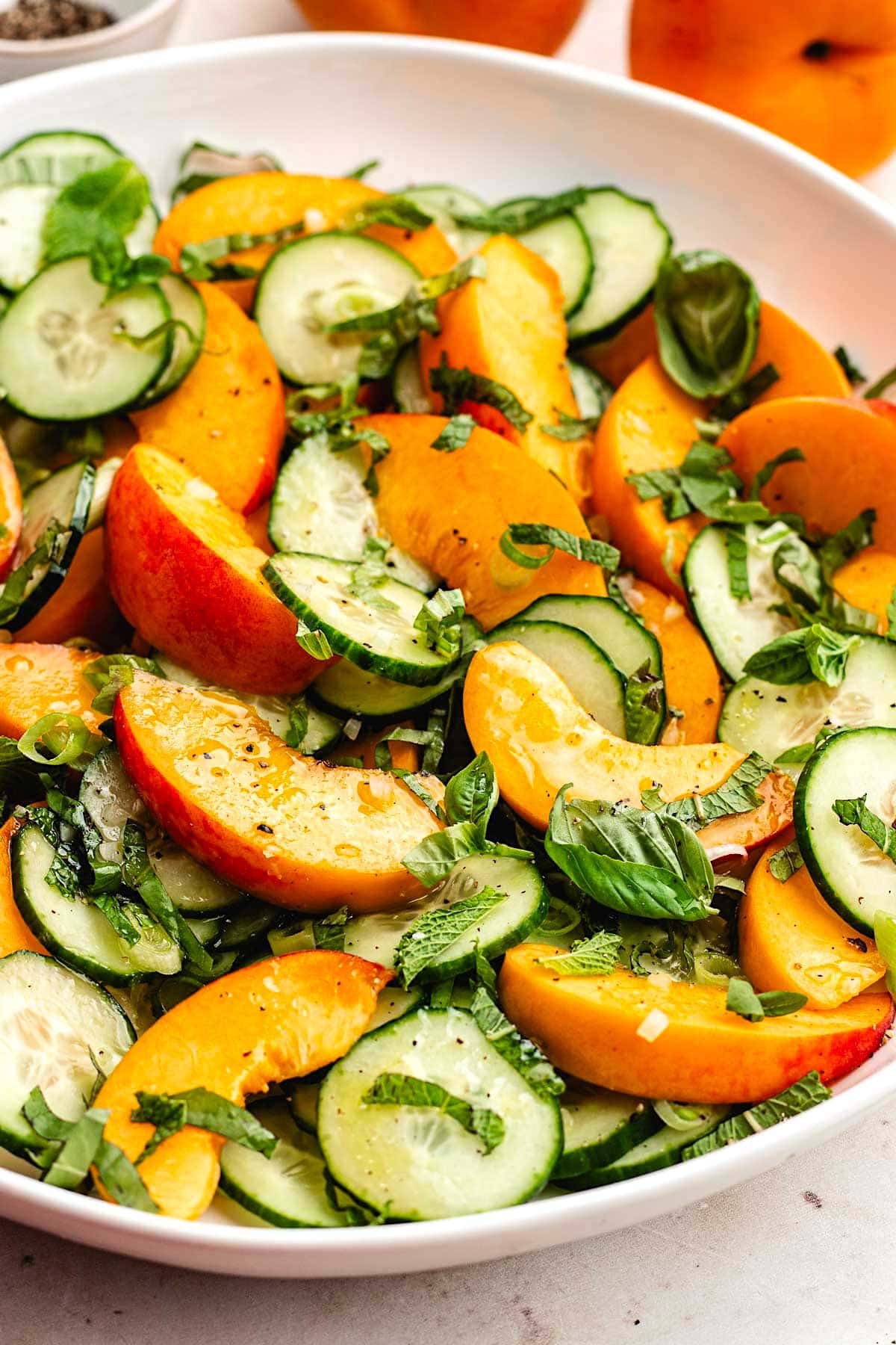 close up of peach cucumber salad with fresh herbs. 