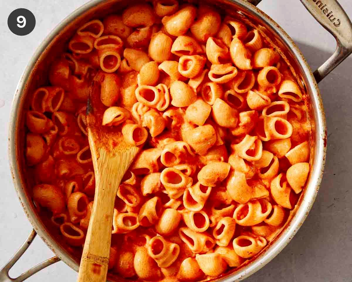 Pasta added to a pan with a creamy tomato sauce.
