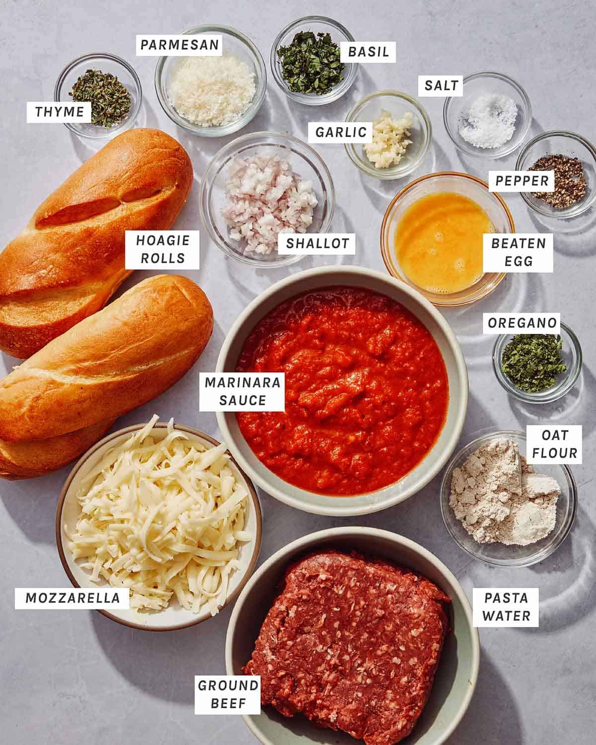 All of the ingredients to make a meatball sub laid out on a kitchen counter.