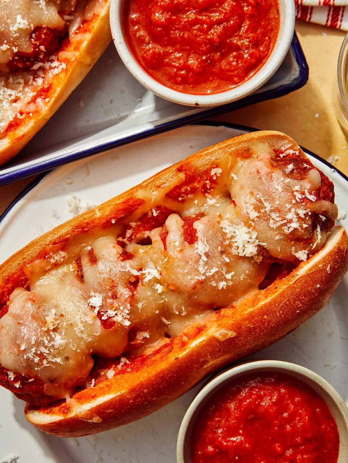 Close up on a plate with a meatball sub on it.