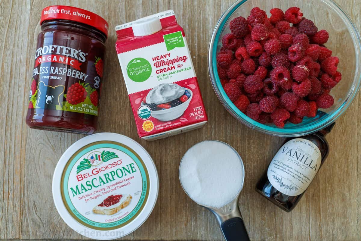 Raspberry Swiss Roll Cake wraps moist sponge cake around a sweet and creamy mascarpone filling. Sounds difficult, but it couldn't be easier! Ingredients for raspberry Swiss Cake Roll recipe including raspberry preserves, heavy whipping cream, mascarpone cheese, sugar, vanilla, and fresh raspberries