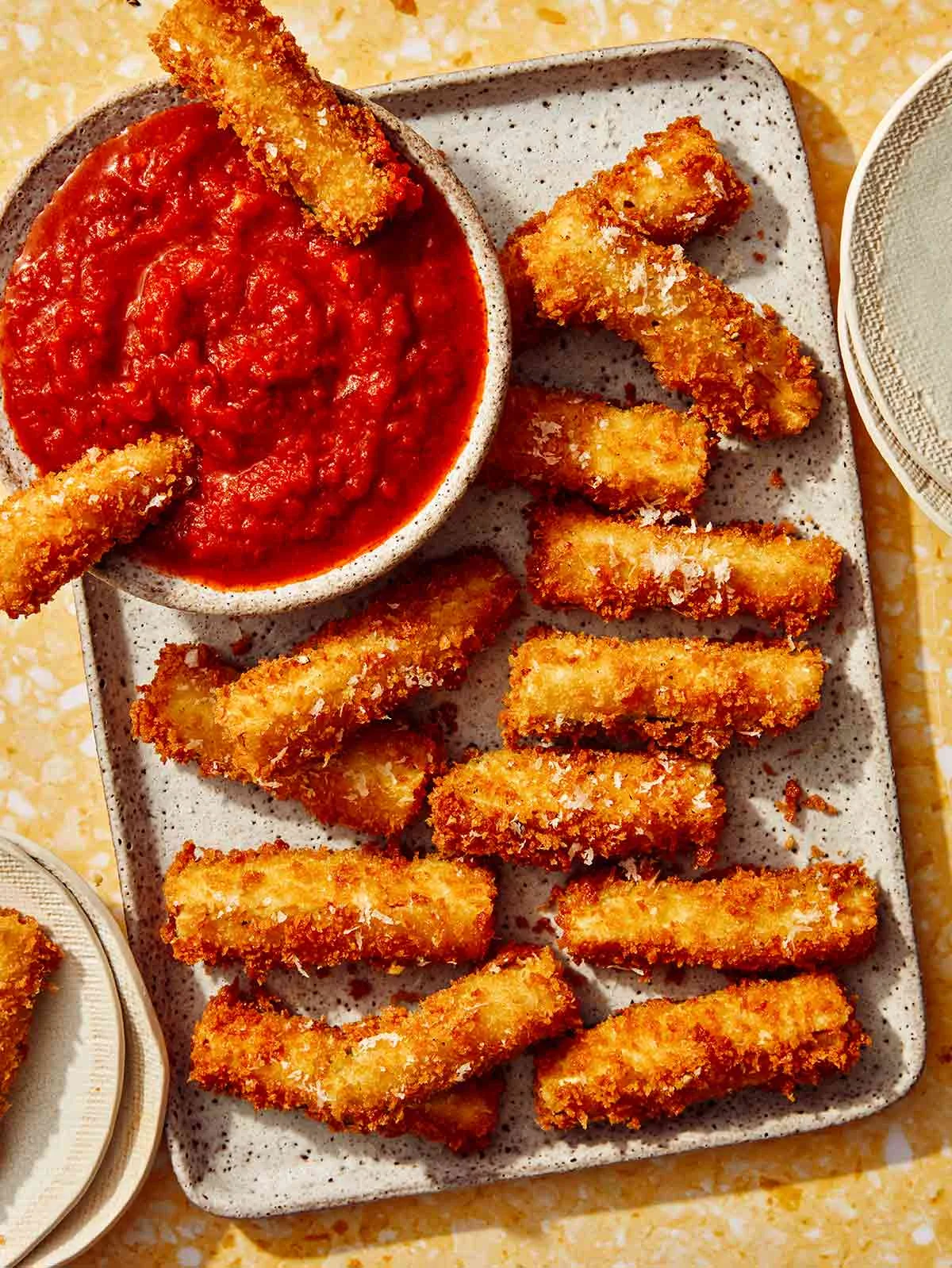 Fried zucchini on a platter being served to guests.