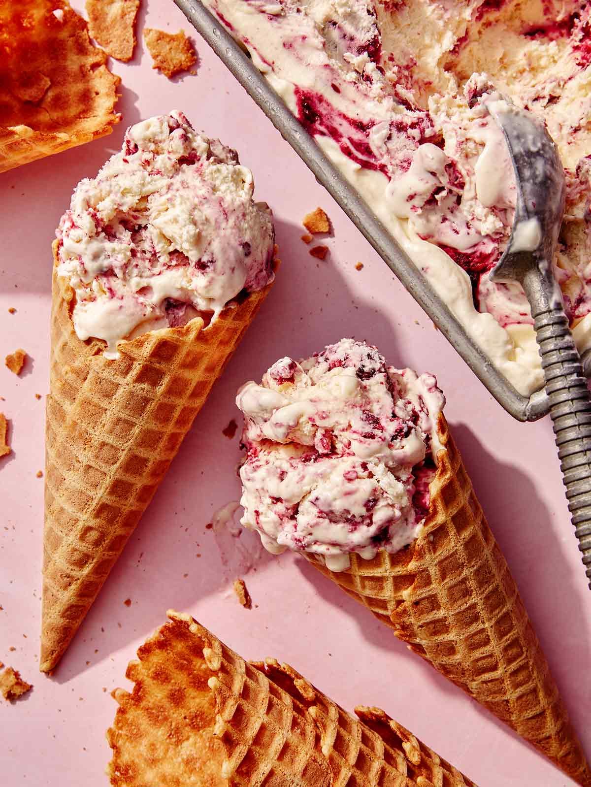 No churn ice cream with waffle cones next to the container. 