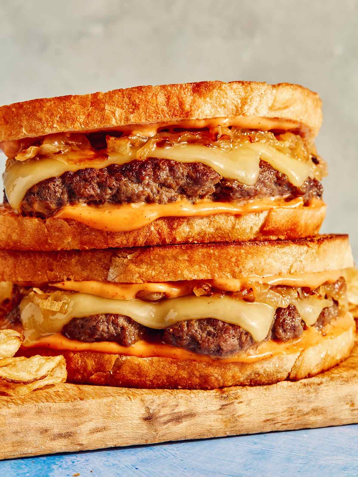 Patty melts on a cutting board.