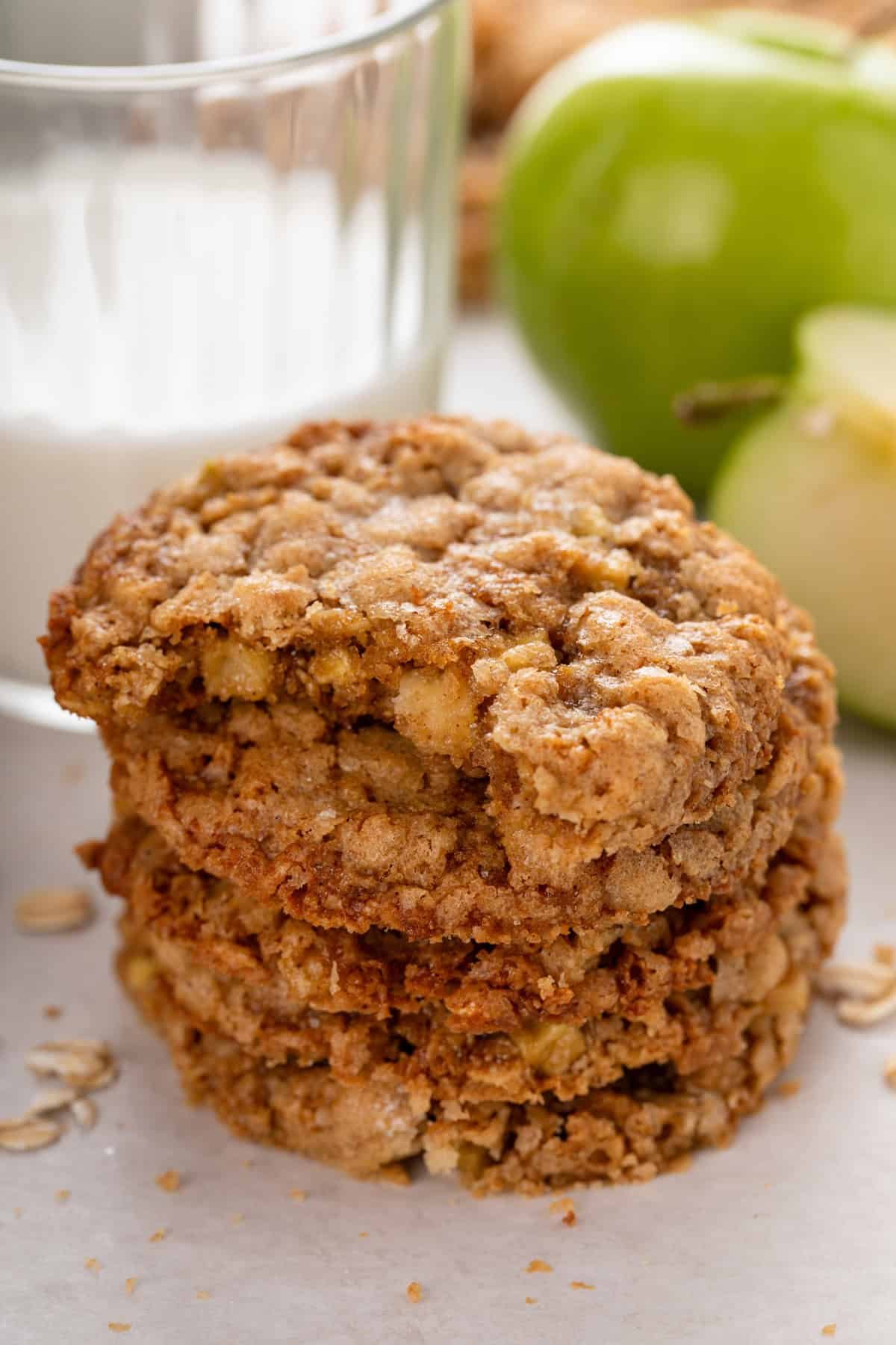 Bite taken from an apple spice cookie on the top of a stack of the cookies.