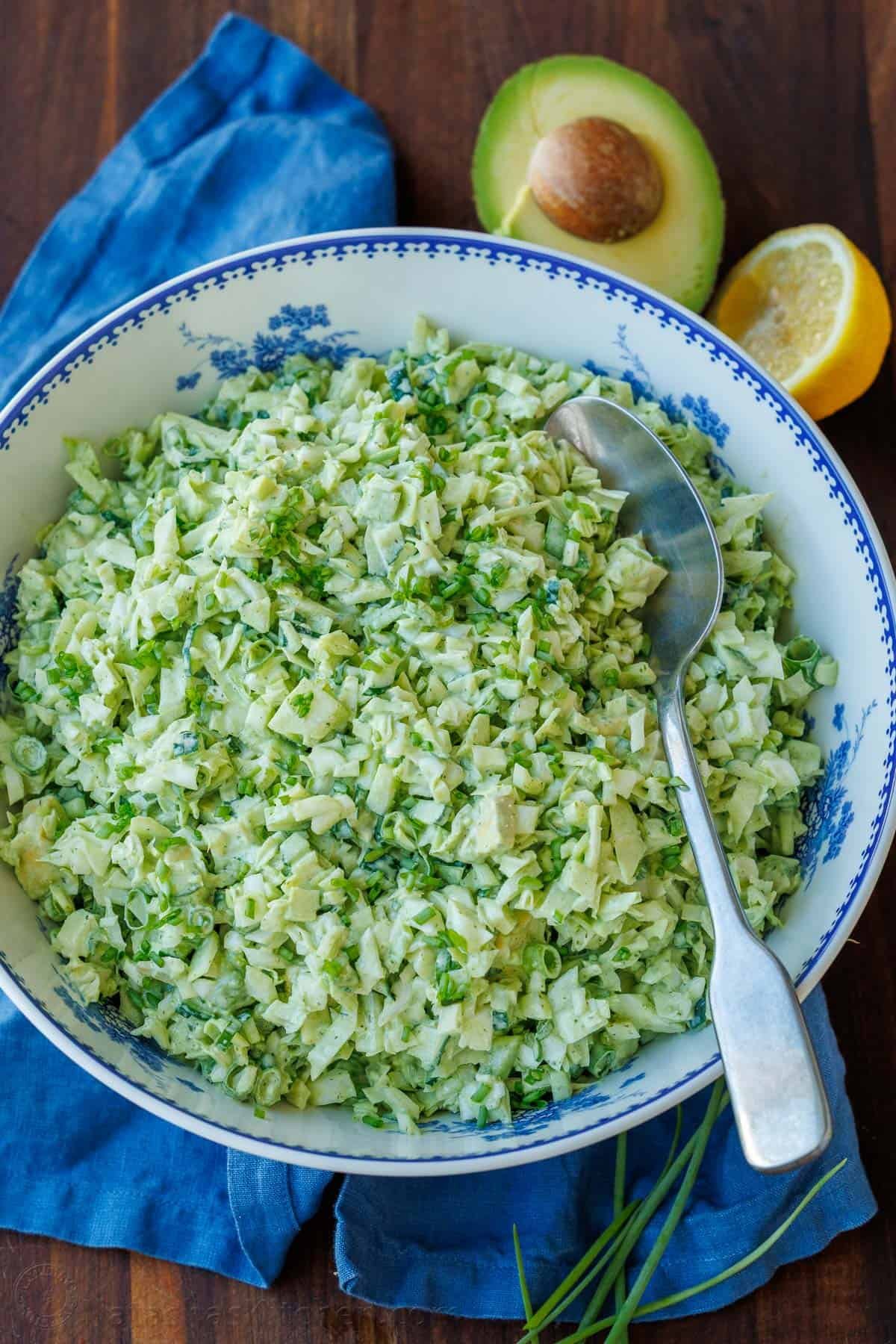 Green Goddess chopped salad in a bowl with avocado slices and a spoon
