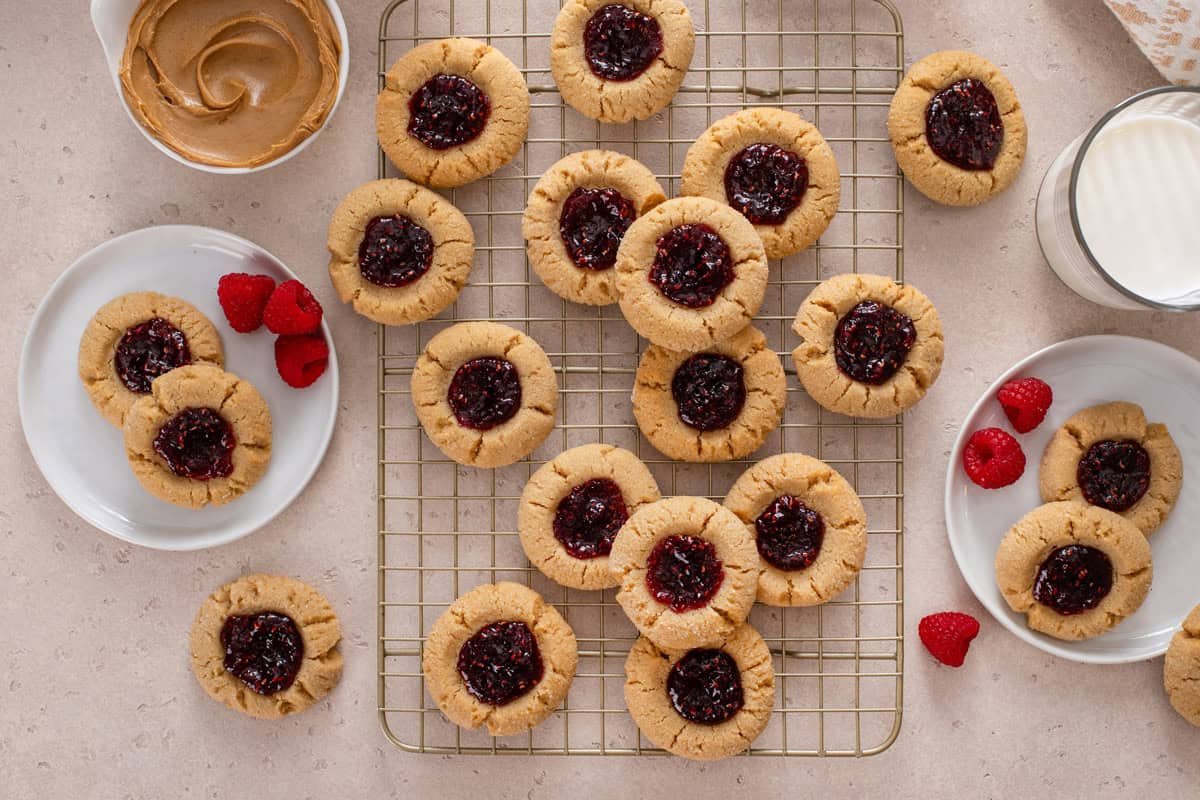 Overhead view of peanut butter and jelly cookies cooling on a wire rack.
