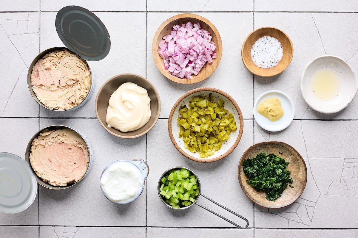 canned tuna and ingredients in bowls to make tuna salad. 