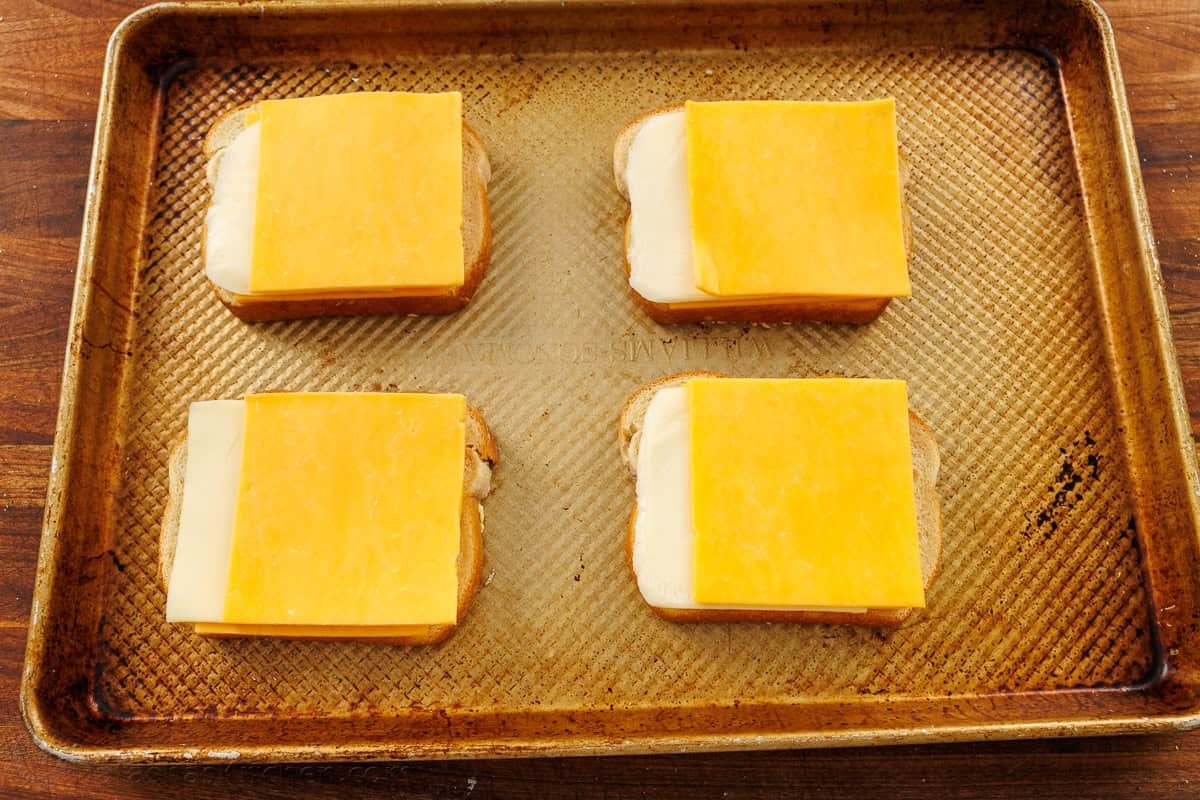 How to make baked grilled cheese using slices of bread, two kinds of sliced cheese and a sheetpan in the oven