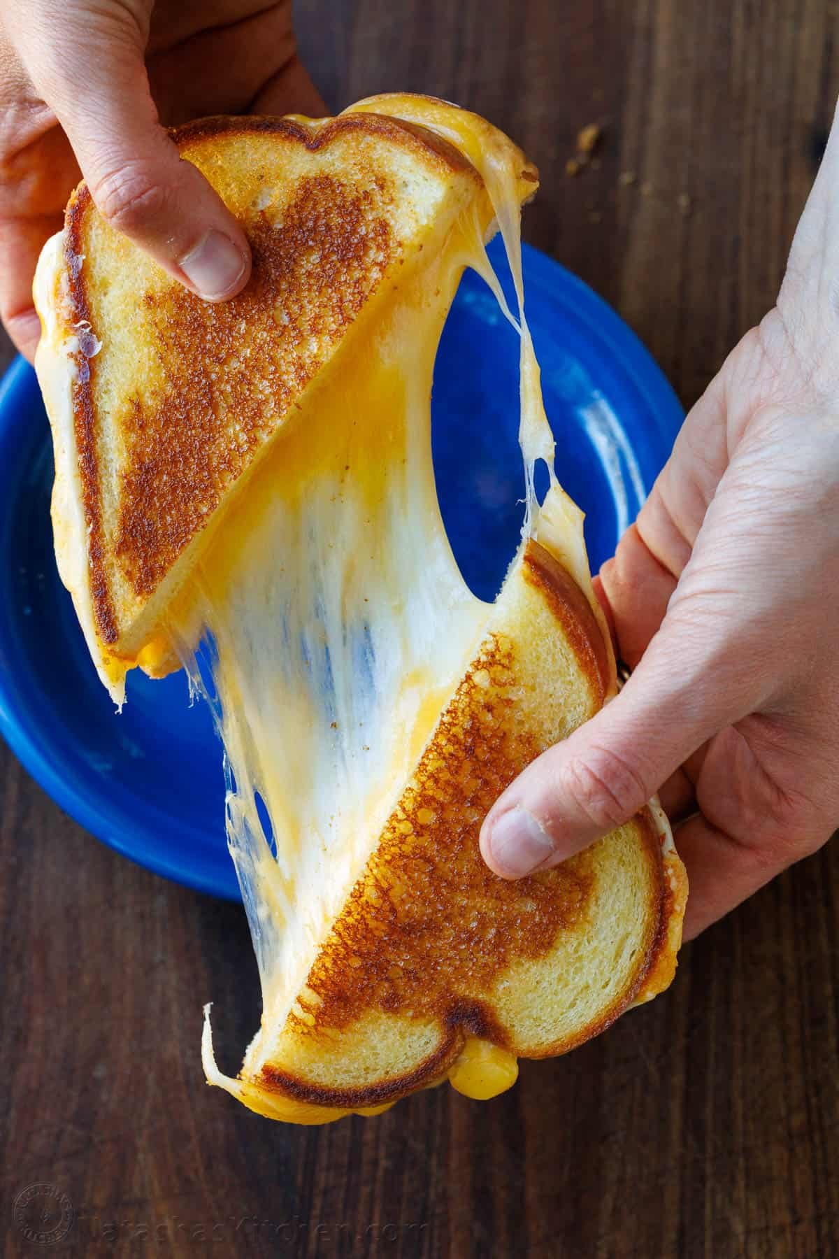 melty grilled cheese from the oven cut in half with pulled cheese