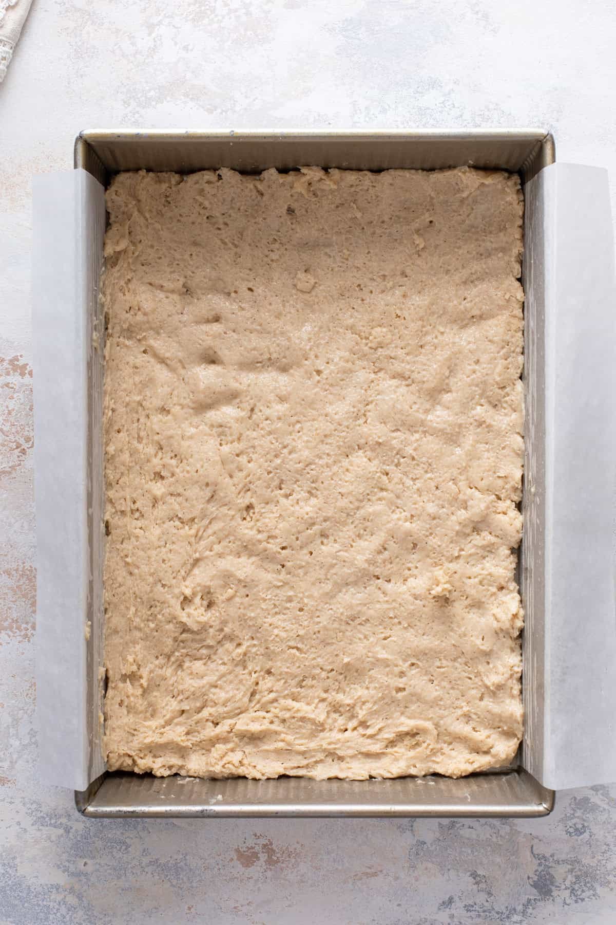 Bottom layer of batter spread into a pan for cream cheese coffee cake.