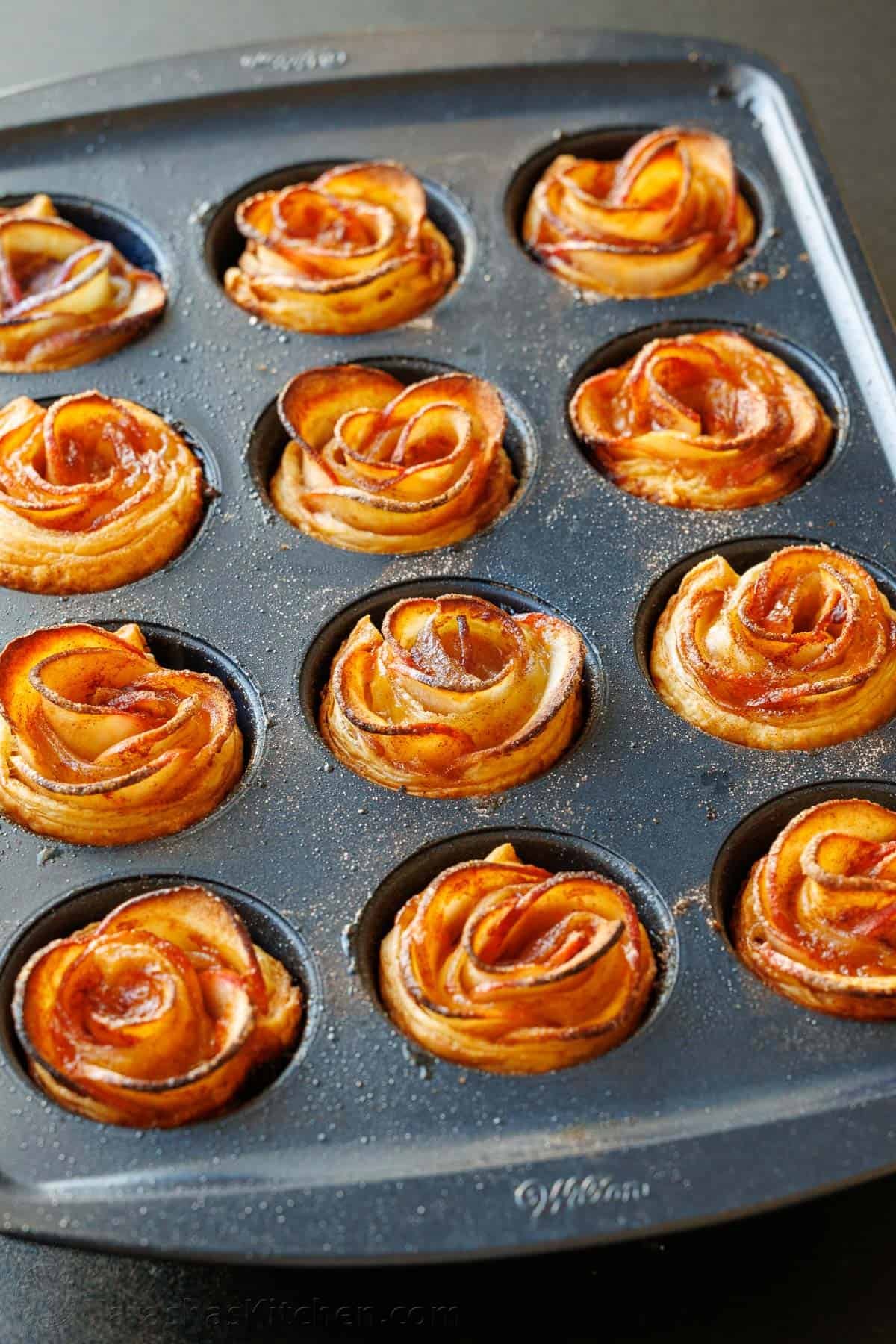 Easy Apple roses taste just like classic apple pie, but look festive and beautiful! Tey are easy to make and perfect as a holiday dessert. Apple roses recipe in a muffin tin with browned edges