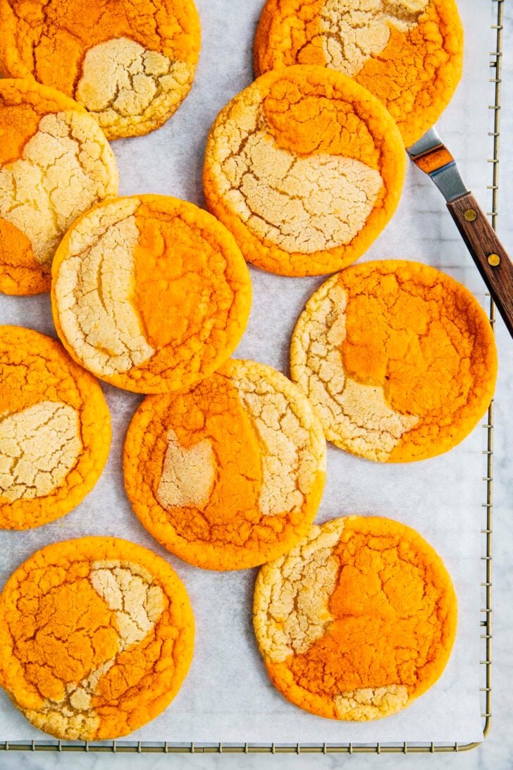 photo of thai tea cookies on parchment paper on a gold wire rack