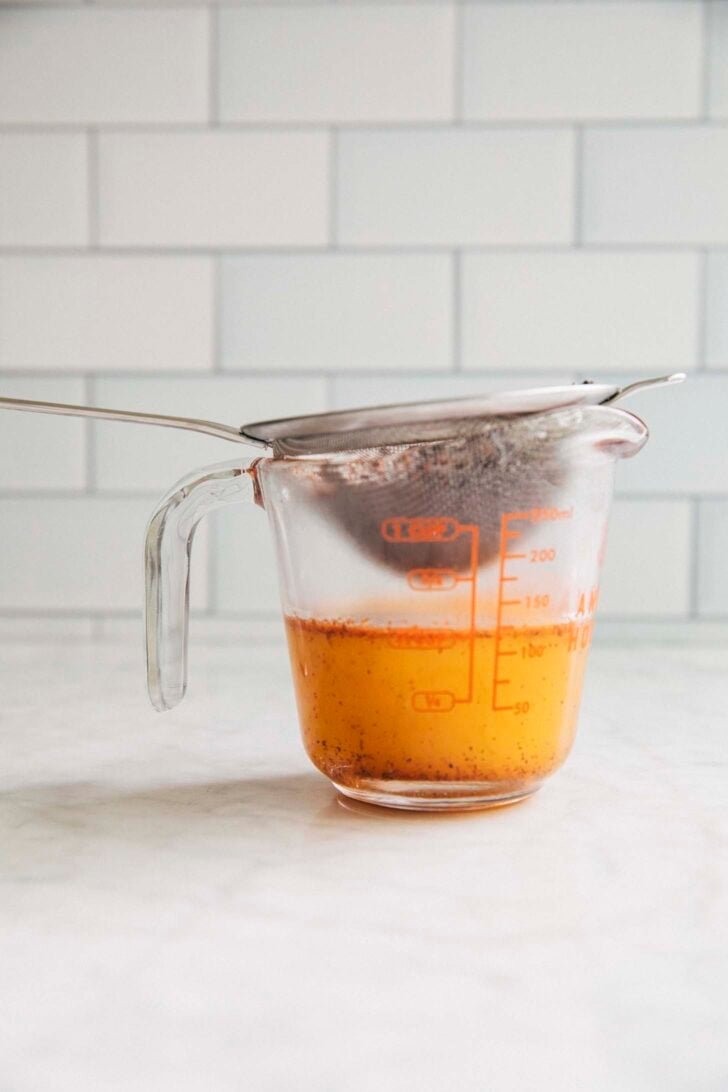 photo of Thai tea butter being strained into a liquid measuring cup
