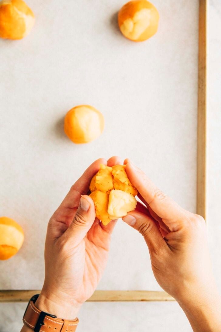 photo of Michelle from Hummingbird High pressing Thai tea and Sweetened Condensed Milk cookie dough balls together to form a Thai tea cookie