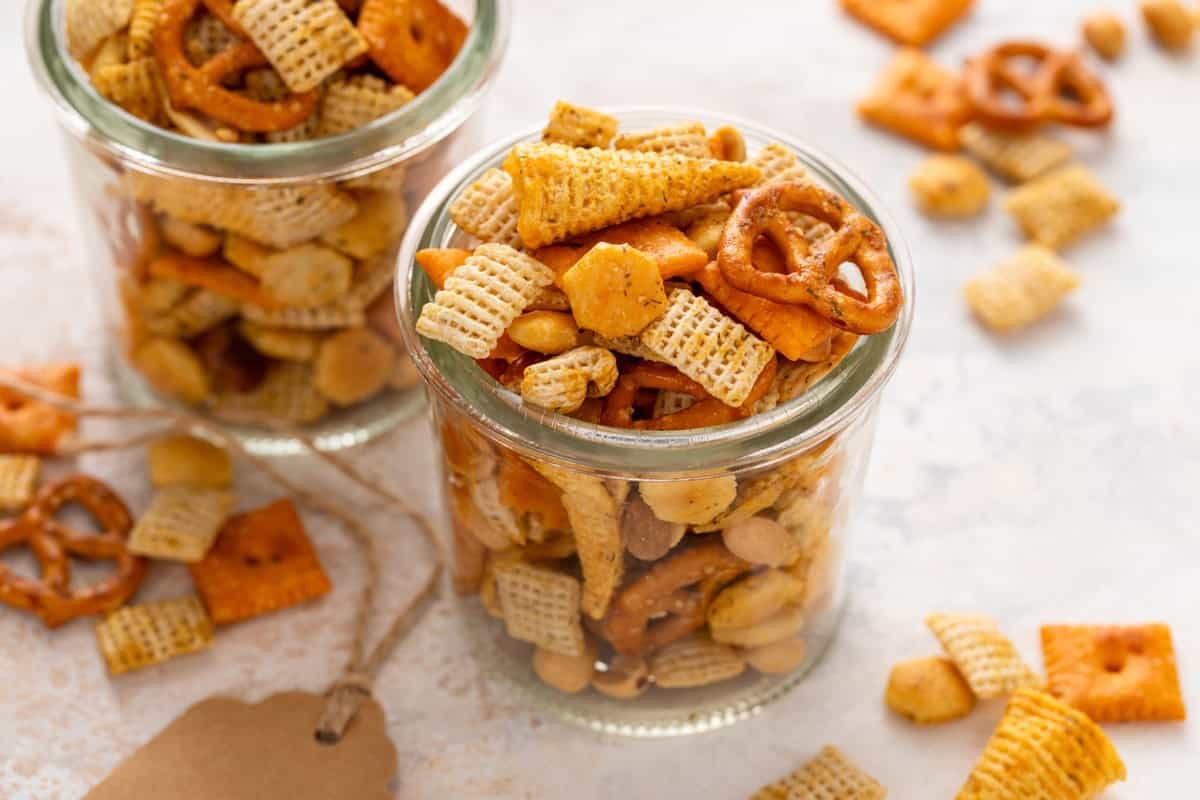 Glass jar filled with ranch chex mix, set on a countertop.