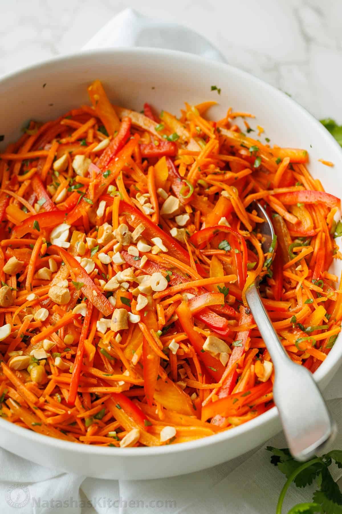 Spicy Korean Carrot Salad packs so much flavor into one crowd-pleasing side dish. The easy dressing melds the whole salad together in minutes. Spicy Korean Carrot Salad in a white bowl with a fork