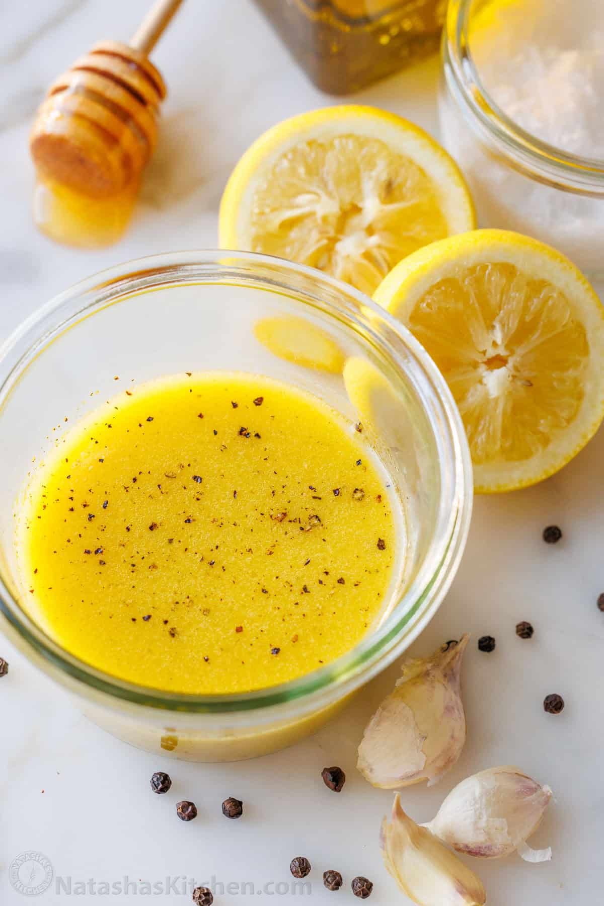 Lemon Vinaigrette dressing comes together quickly, but will become your go-to homemade salad dressing. Use for salads, to marinate, or more. jar of easy lemon vinaigrette salad dressing garnished with pepper and surrounded by fresh ingredients