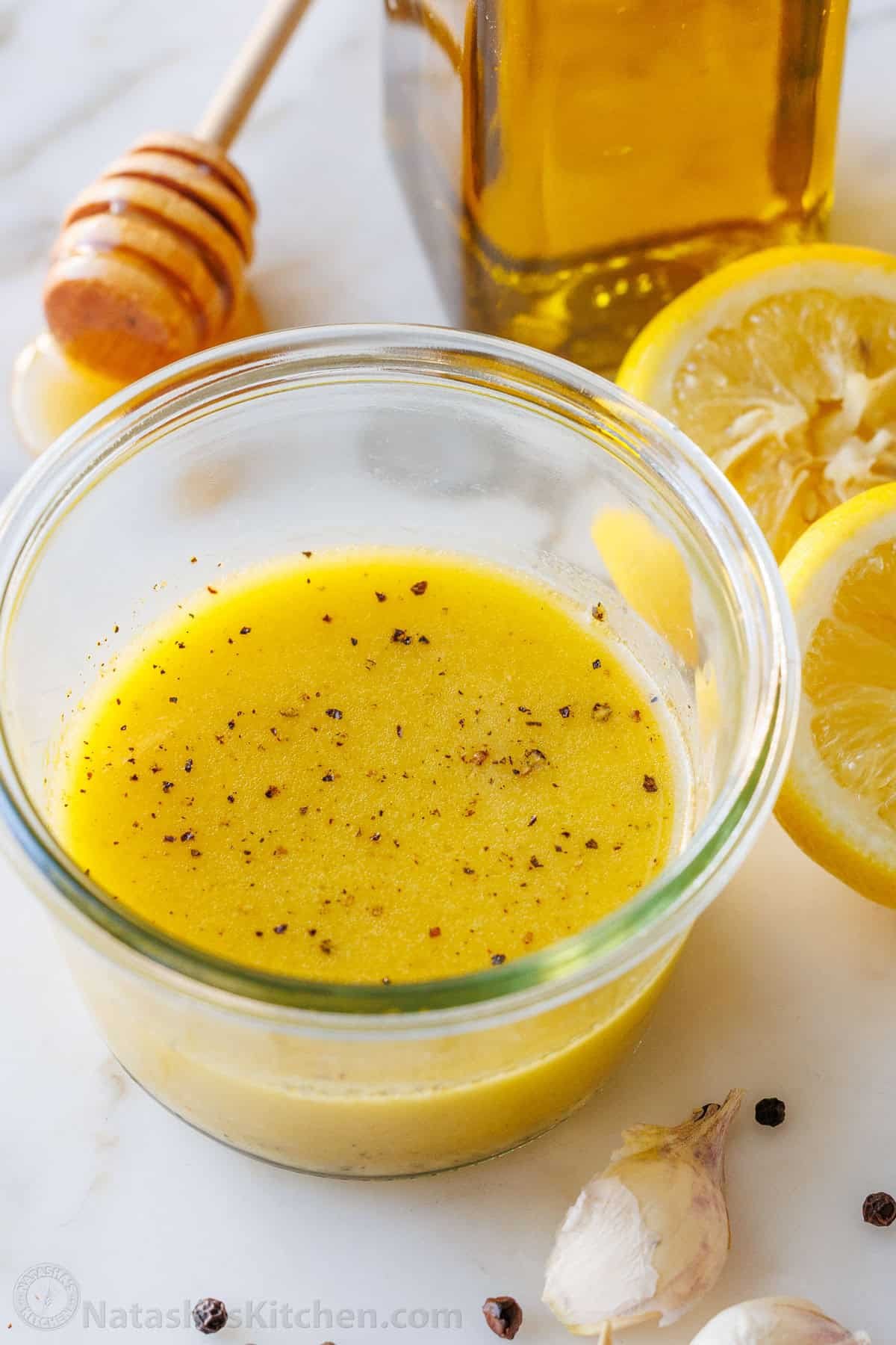 Lemon Vinaigrette dressing comes together quickly, but will become your go-to homemade salad dressing. Use for salads, to marinate, or more. Lemon vinaigrette dressing recipe with garlic, pepper, lemon slices and honey