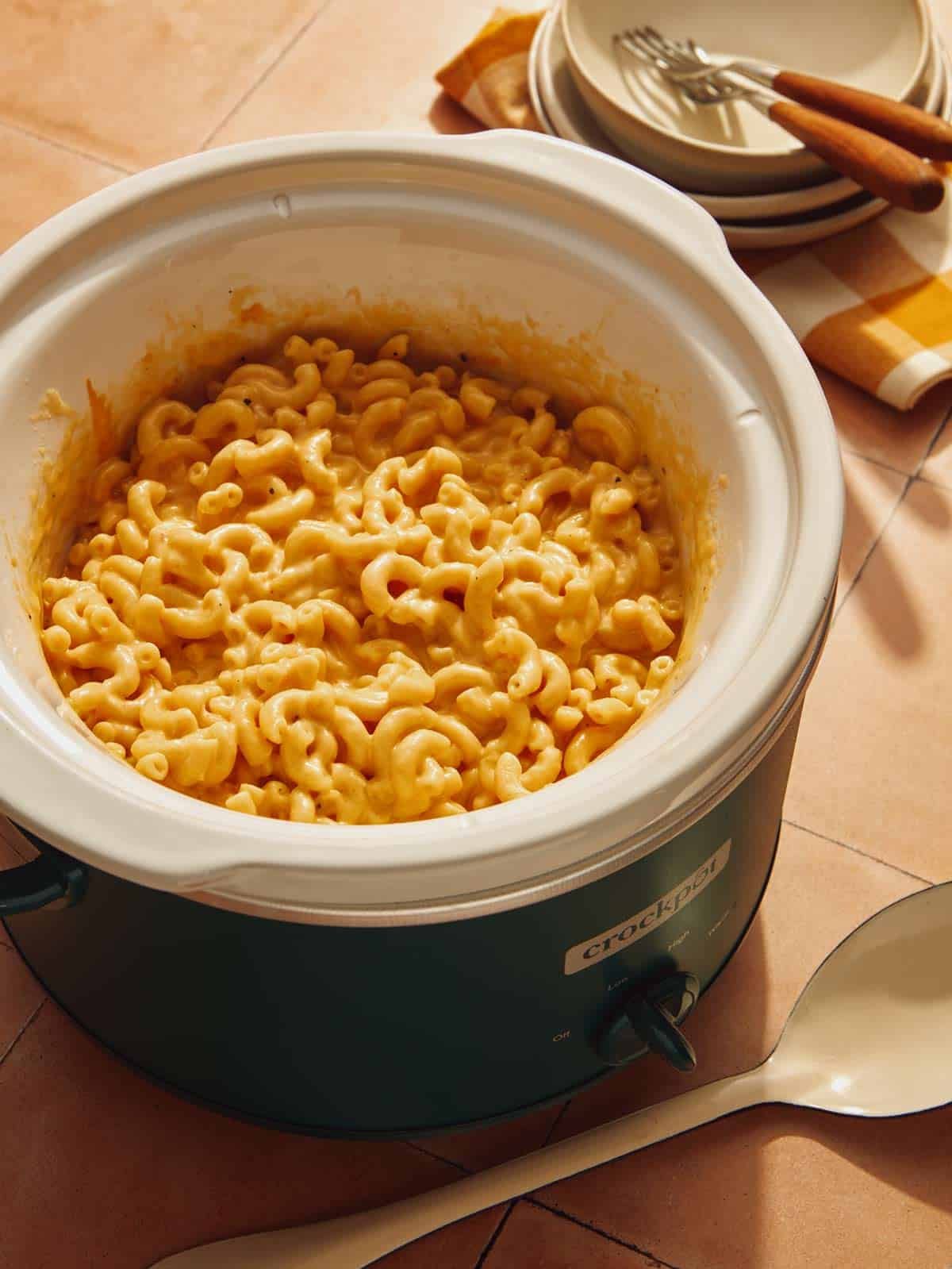 A crock pot filled with fresh macaroni and cheese.