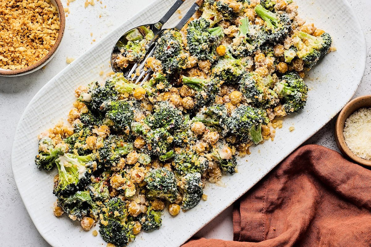 roasted broccoli caesar salad on platter with chickpeas, toasted breadcrumbs, and parmesan cheese.