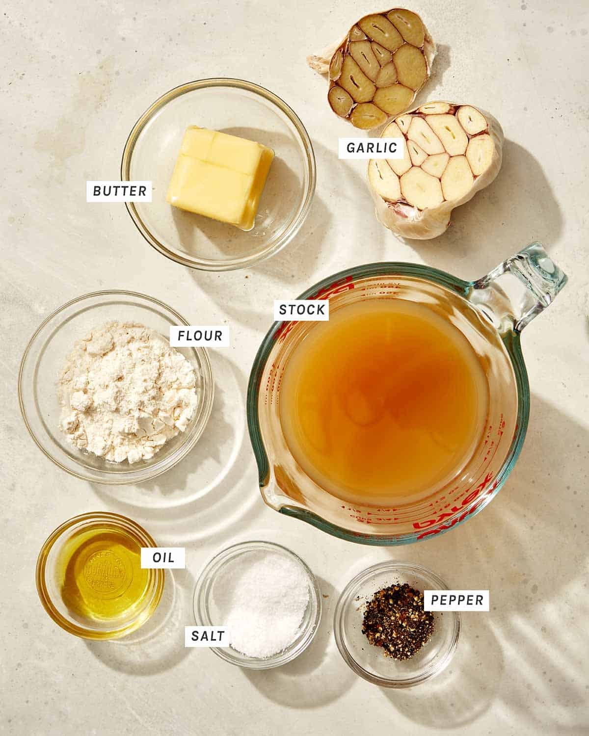 Roasted garlic gravy recipe ingredients on a kitchen counter.