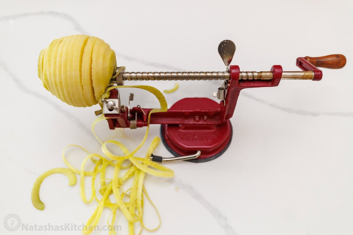 Bakery-style Apple muffins with crumb topping are so easy to make, with a moist crumb and chunks of apple inside. Uses just pantry staples. apple peeler removing peel from apple