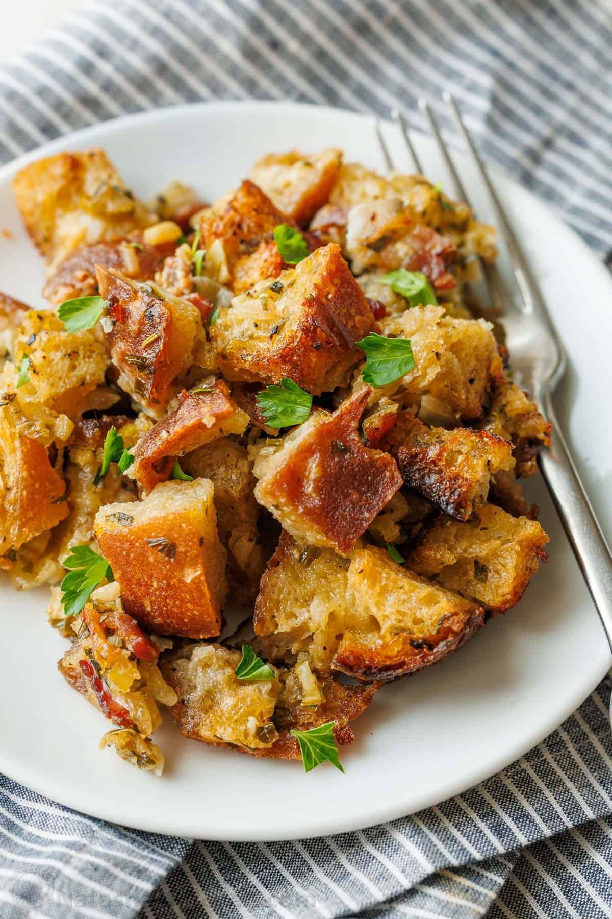 Stuffing recipe on a white plate with fork and striped napkins
