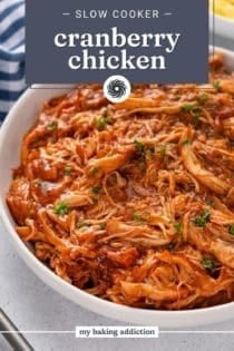 Close up of cranberry chicken in a white serving bowl. Text overlay includes recipe name.