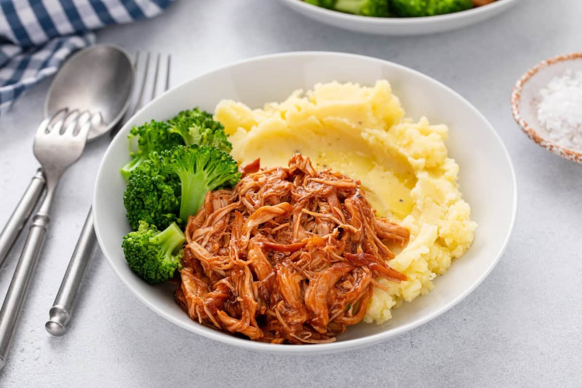 Cranberry chicken plated with mashed potatoes and broccoli.