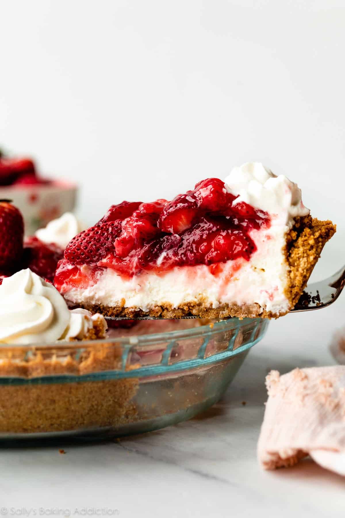 removing slice of strawberry cream cheese pie from pie dish