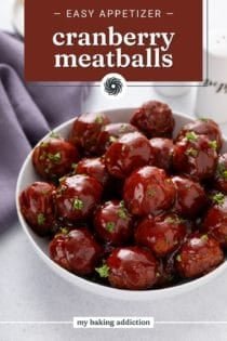 White serving bowl filled with cranberry meatballs. tExt overlay includes recipe name.