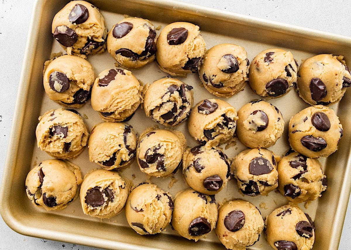 chocolate chip cookie dough balls on baking sheet. 
